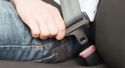 Close Up photo of a man buckling his seat belt