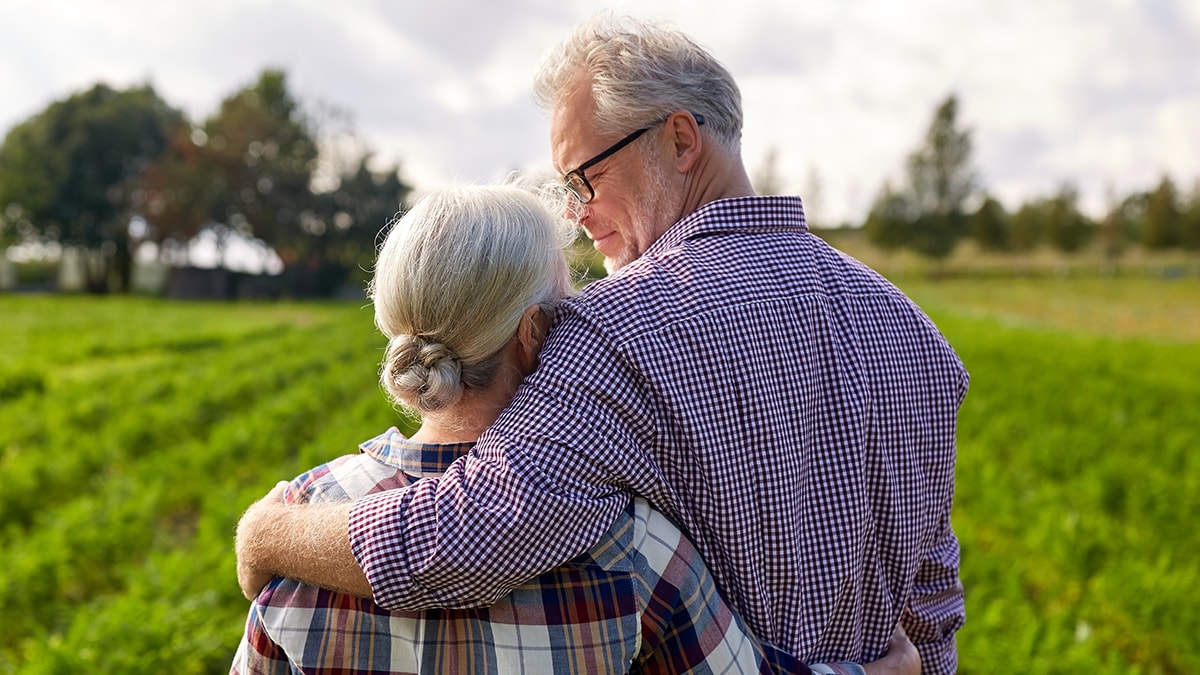 Couple in field with arms around each other