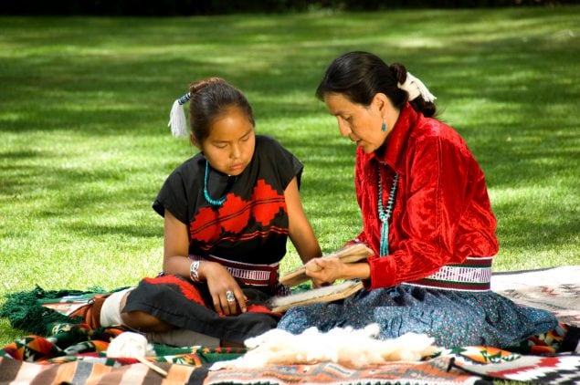 Two native Americans Learning how to weave