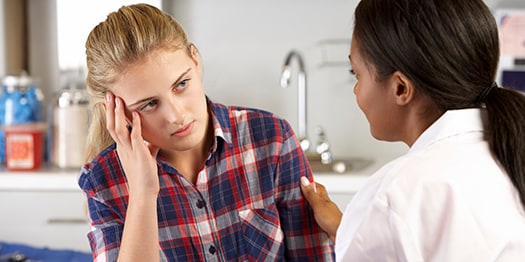Teenage girl speaking to doctor