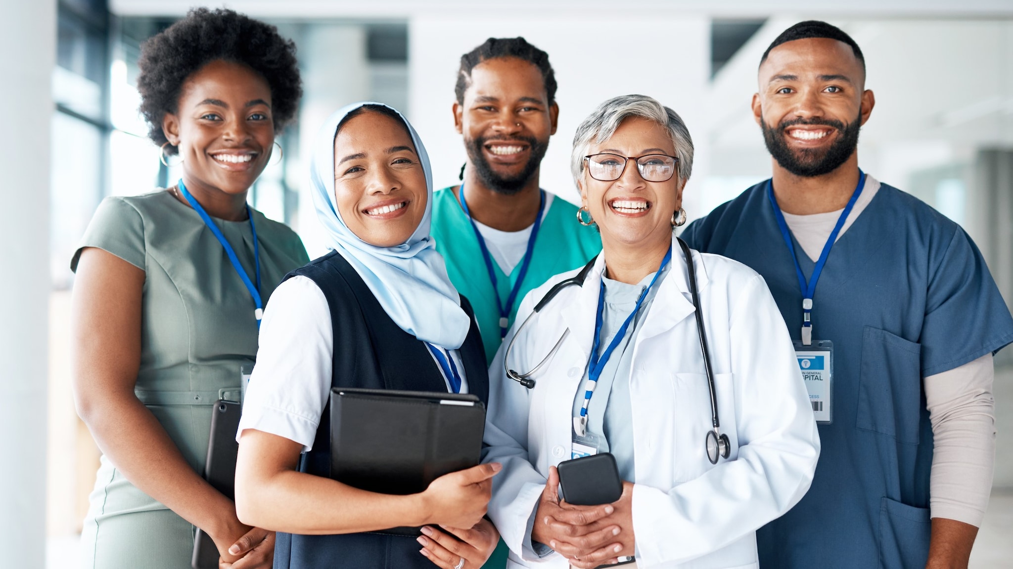 A diverse group of healthcare providers standing together for a photo, representing different ages, races, and ethnicities.