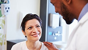 Médico hablando con una paciente sonriente