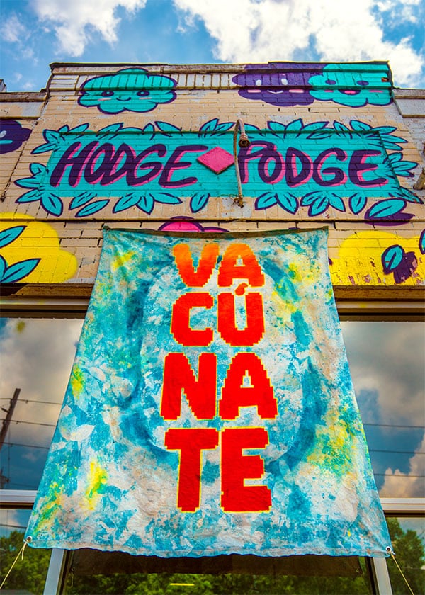 Photo of a hanging canvas displaying 'VACUNATE'