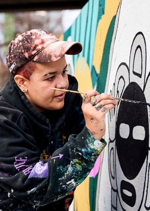 Female artist painting on a wall