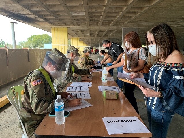Teachers completing the COVID-19 vaccine screening and consent form before getting vaccinated at the Mayagüez site.