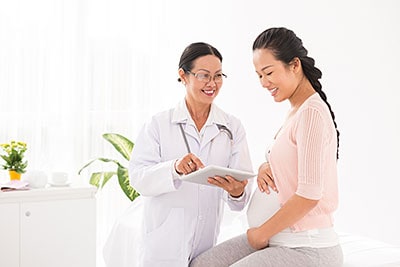 Female doctor talking with pregnant woman