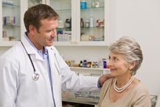 Un médico varón habla con un paciente femenino