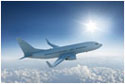 Airliner flying past the sun - in blue sky