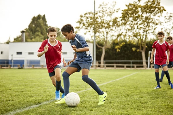 Niños adolescentes jugando al fútbol (soccer)