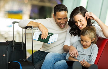 Padre, madre e hija esperando en un aeropuerto