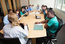 Médicos sentados alrededor de una mesa de conferencias