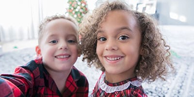 preschool age siblings taking Christmas morning selfie together
