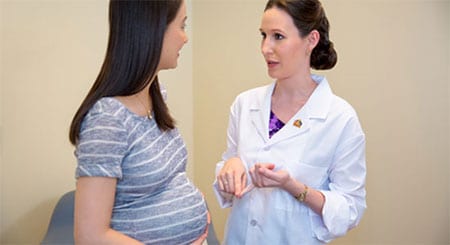 female doctor talking with a pregnant patient