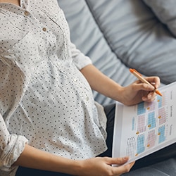 mujer embarazada marcando un calendario