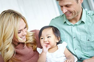 couple smiling with toddler girl