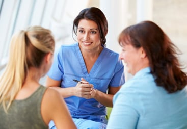 nurse talking to teenager and her mom