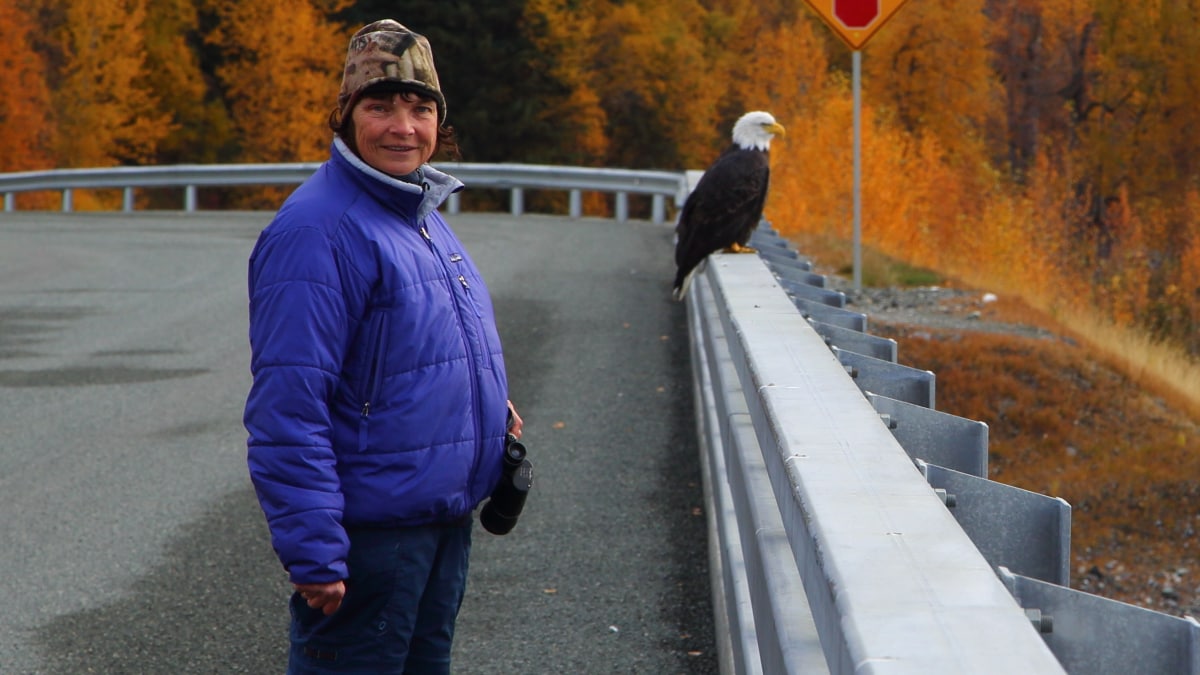 woman standing outside near a bald eagle