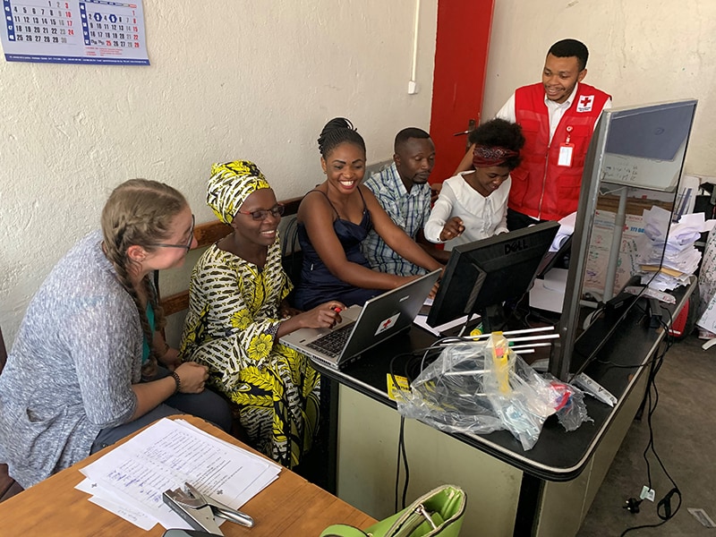 CDC’s Vivienne Walz, left, works with Bora Kahindo, Wivine Kabuo Mwambawsi, Justin Bisimwe, Jeanne Shabani and Héritier Malukite of the DRC Red Cross to enter comments about the Ebola response from people in communities in and around Goma