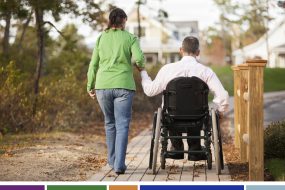woman holding husband's hand who is in a wheelchair