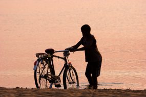 boy washes his bike in the lake malawi