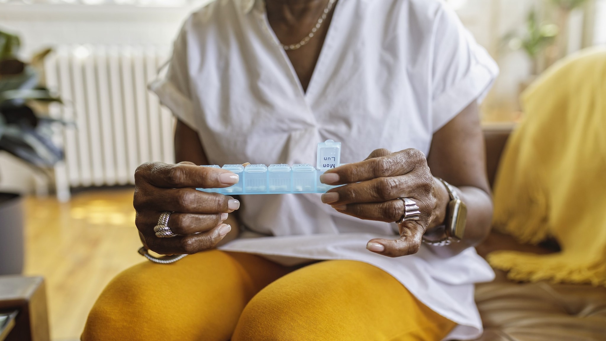 Older adult woman looking at her pill container