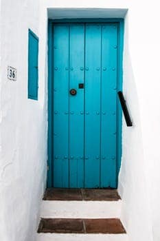 close up of a turquoise door on a white stucco building