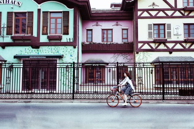 Example image: woman bicycling through village