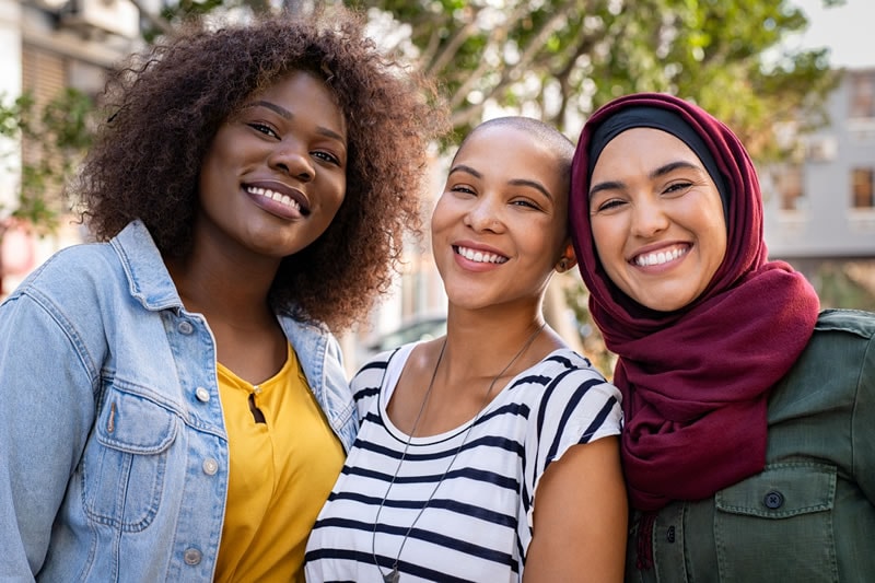 three diverse women outside smiling