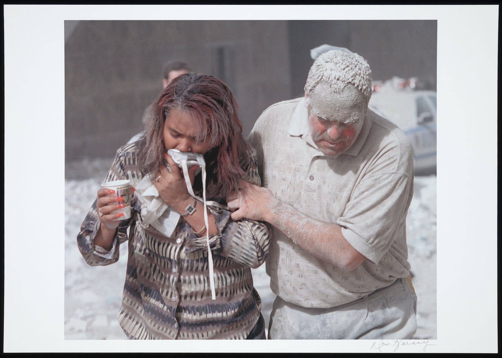 Two people covered in dust evacuate from Ground Zero.