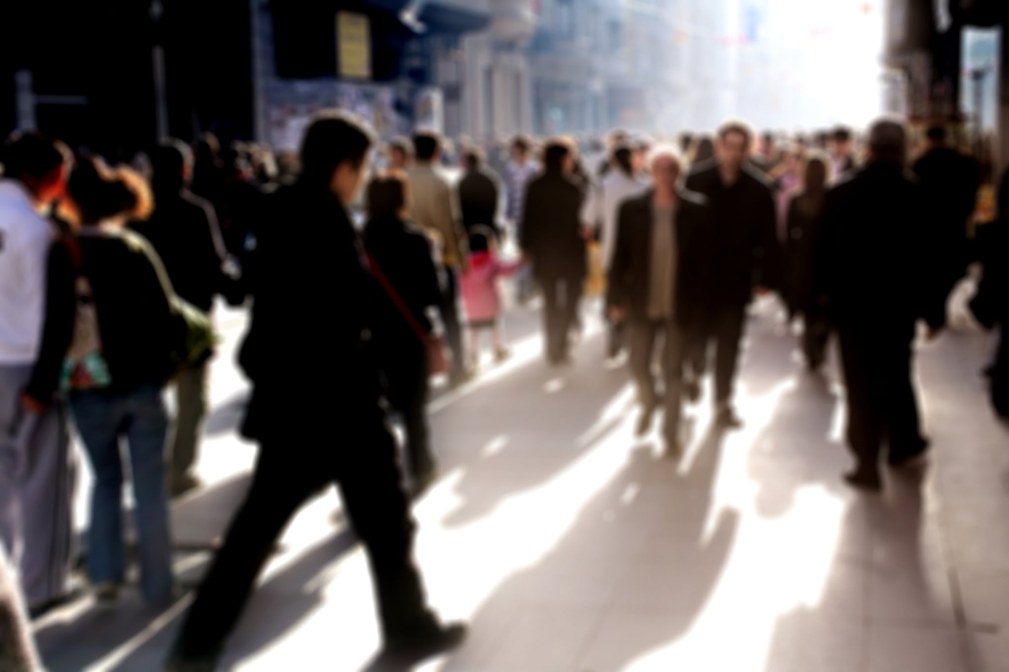 People are walking on a crowded street. The blurry photo implies action or urgency.