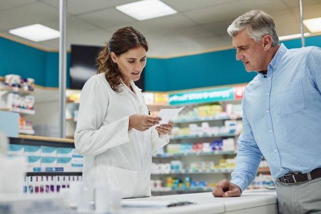 Pharmacist reviewing a prescription for customer.