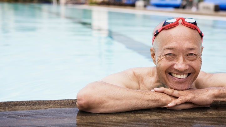 Smiling senior man swimmer wearing goggles