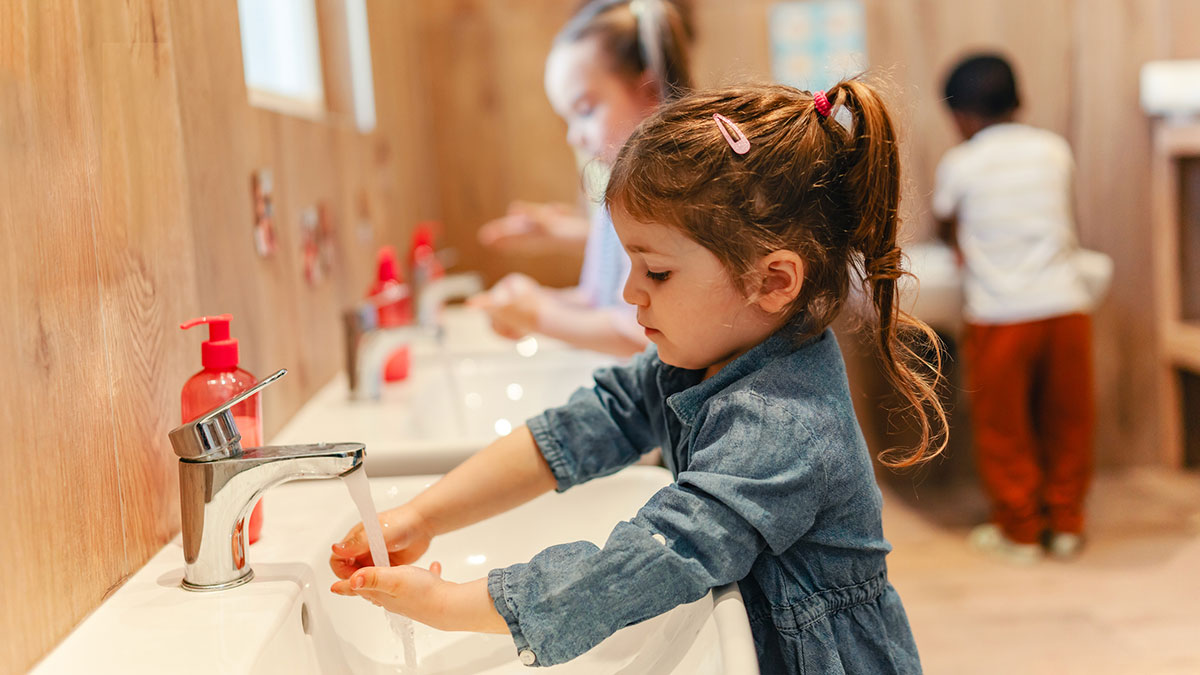 A young girl washing her hands at preschool
