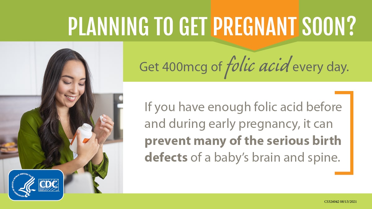 A person reading the label on a supplement bottle with text that reads "Planning to get pregnant soon? Get 400 mcg of folic acid every day."
