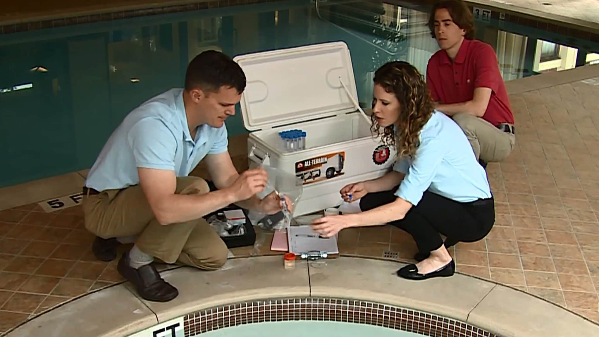 People taking water samples next to a hot tub.
