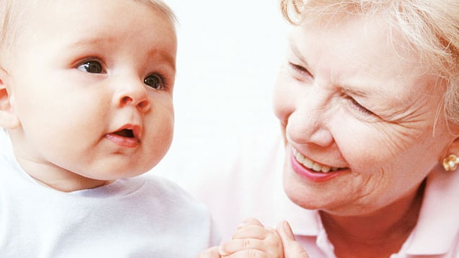A grandmother smiles at her grandchild.